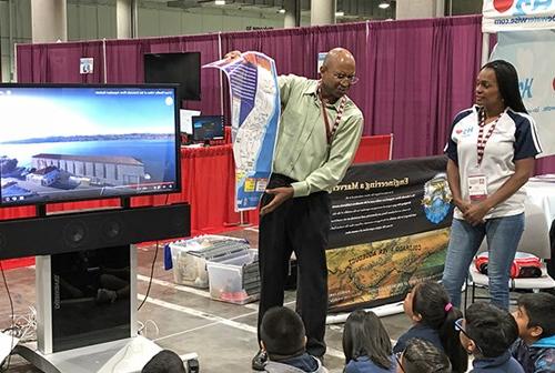 Two Metropolitan staff educate a class on their field trip to a Metropolitan facility